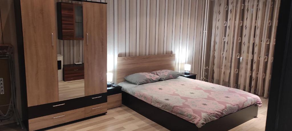 a small bedroom with a bed and a mirror at Apartament Kostov Sliven in Sliven