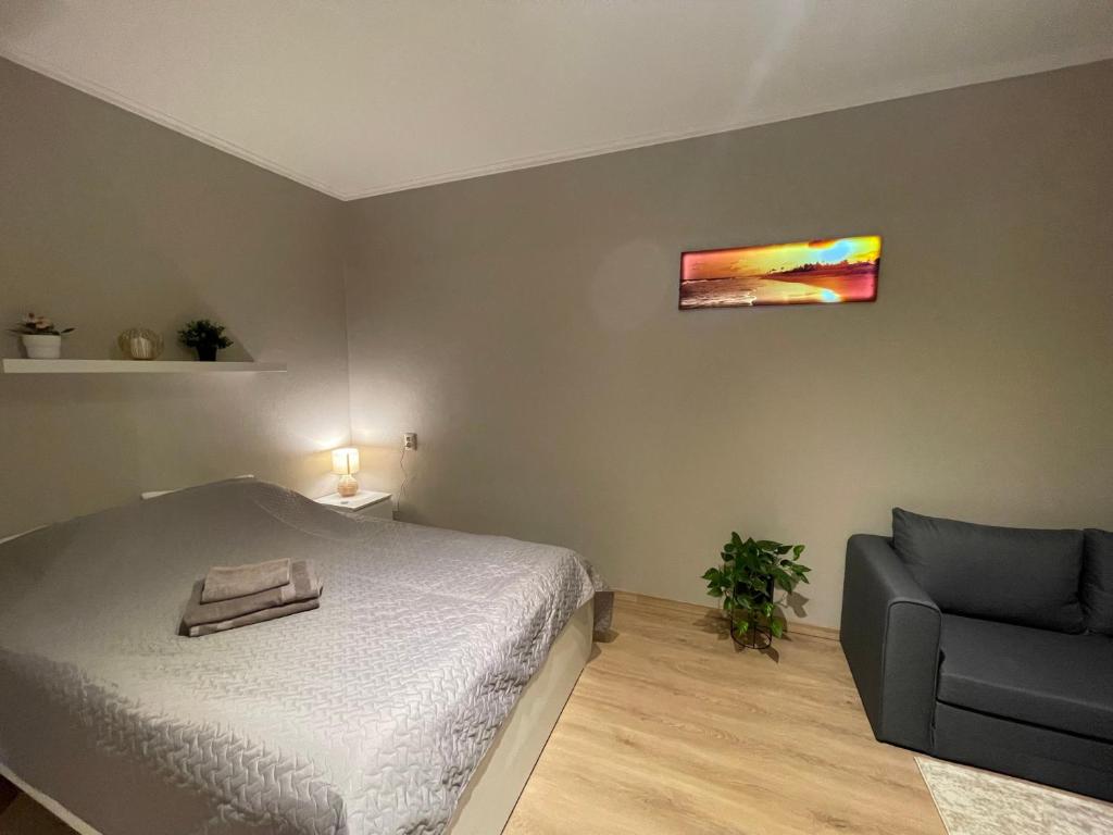 a bedroom with a bed and a chair at Cozy apartment close to Riga Airport in Riga