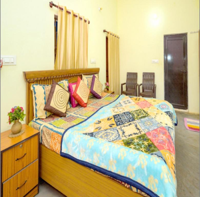 ein Schlafzimmer mit einem großen Bett mit bunten Kissen in der Unterkunft Khajuraho Rancho in Khajurāho
