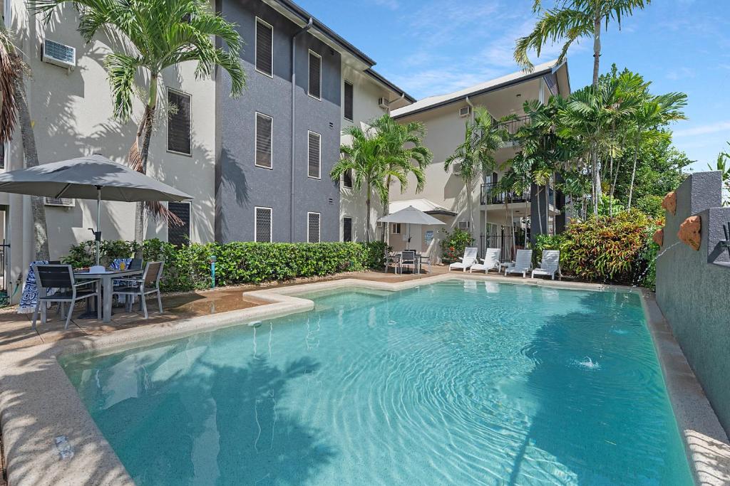 a large swimming pool in front of a building at Bay Village Tropical Retreat & Apartments in Cairns