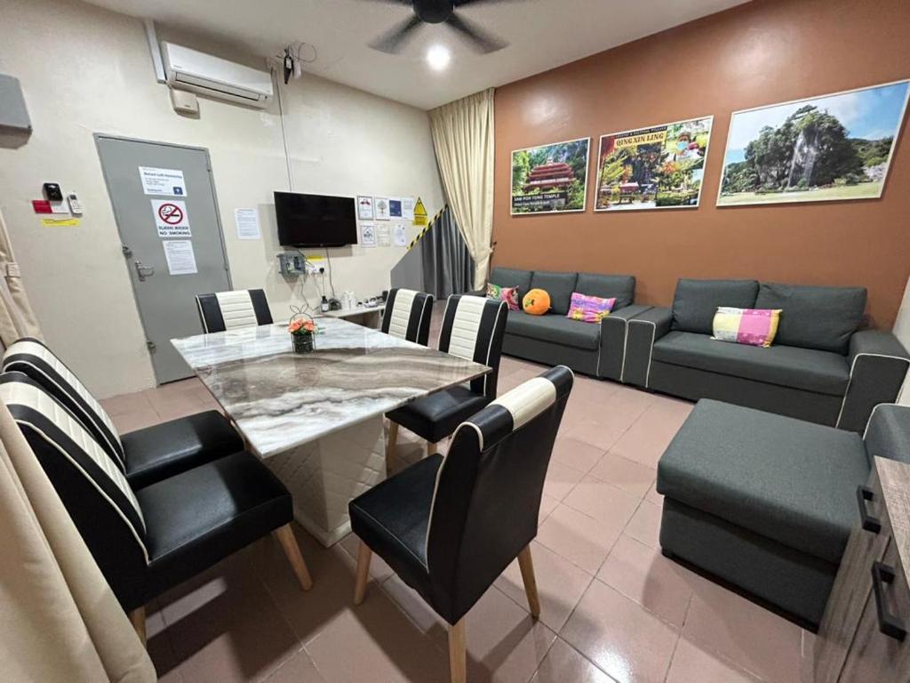 een wachtkamer met een tafel en stoelen en een bank bij BOTANI LOFT HOMESTAY in Ipoh