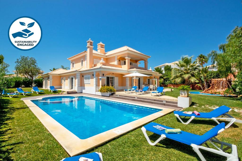 a villa with a swimming pool in front of a house at Villa Savannah by Algarve Vacation in Almancil