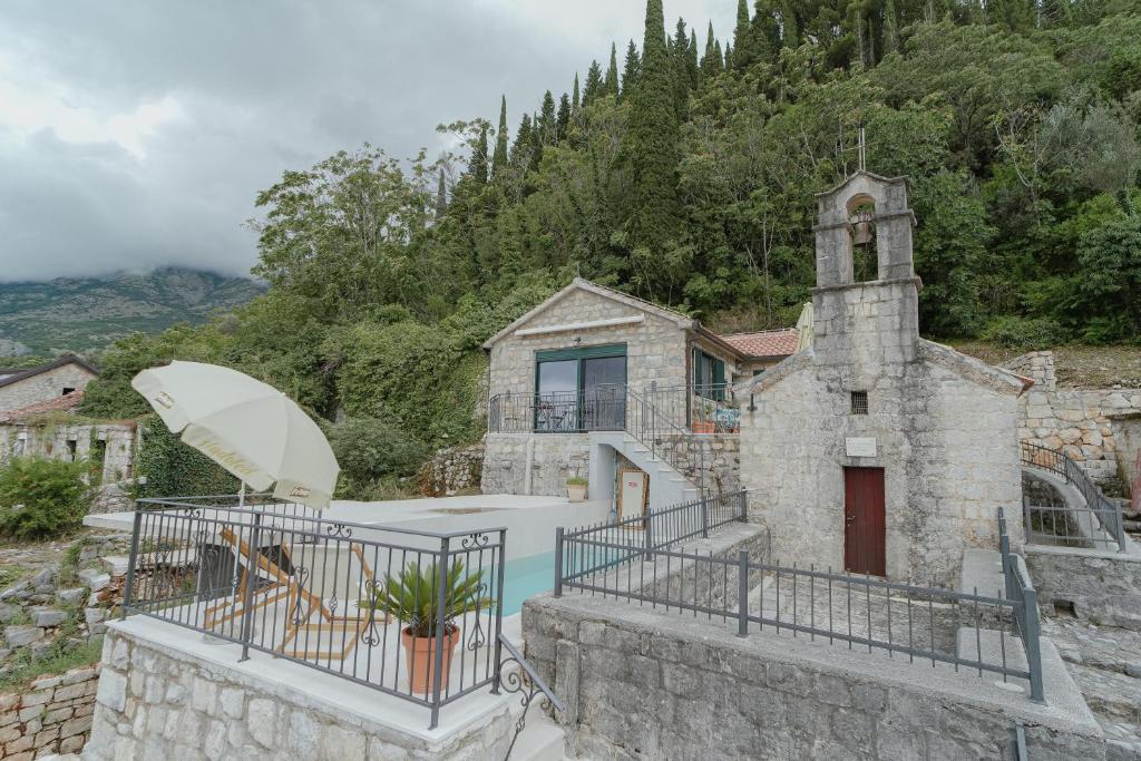 a stone house with a pool and a church at Casa di Pietra in Kotor