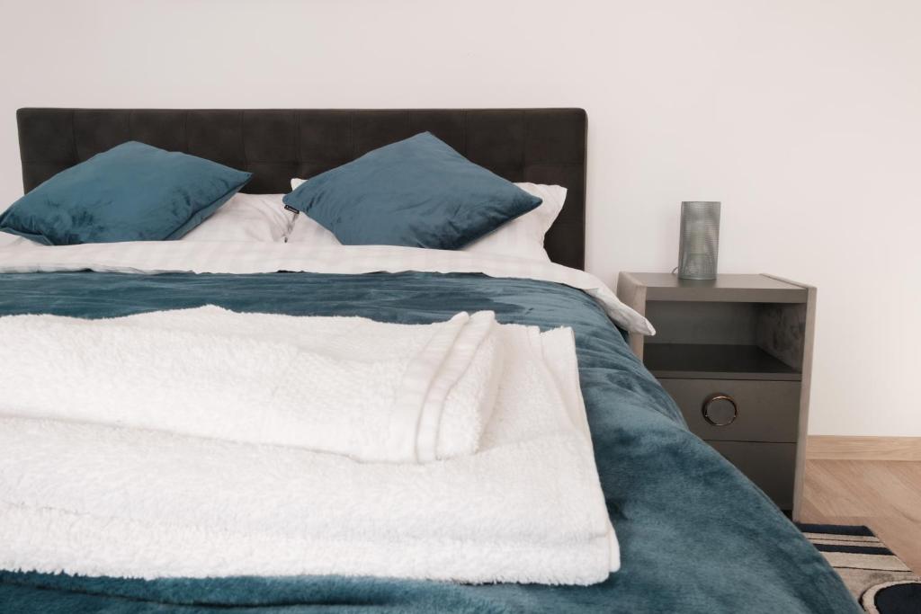 1 cama con sábanas azules y blancas y almohadas azules en Konstanzer Nicolina12 en Iaşi