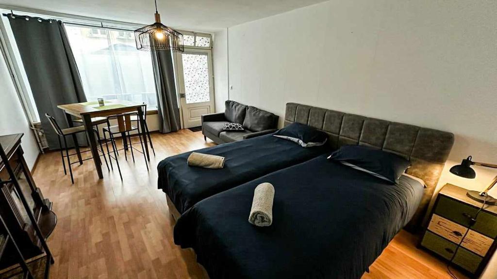 um quarto com uma cama, um sofá e uma mesa em Studio avec kitchenette tout équipée em Porrentruy