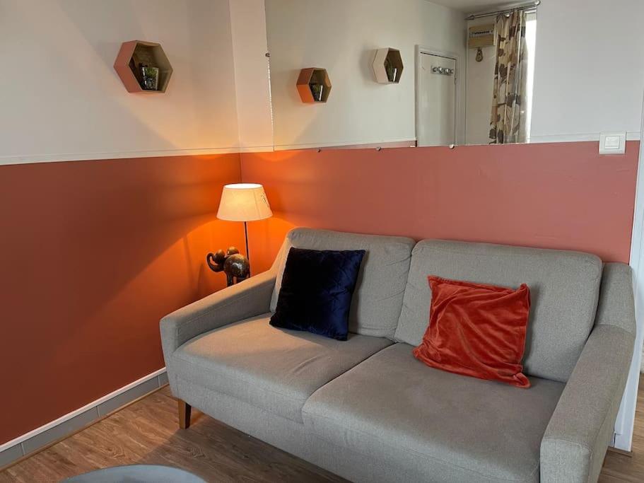 - un salon avec un canapé et 2 oreillers dans l'établissement Chez Loulou - Appartement Honfleur -, à Honfleur