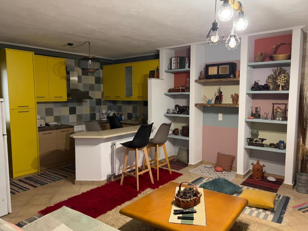 a kitchen with yellow cabinets and a table and chairs at Alonaki House in Amfiklia