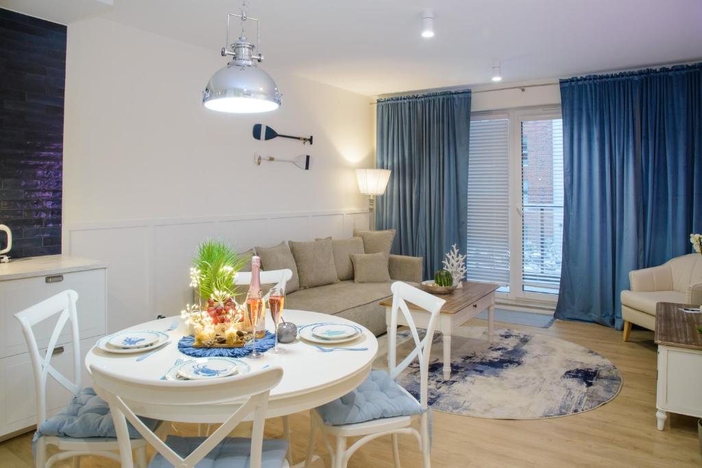 uma sala de estar com uma mesa e um sofá em Maya's Flats & Resorts 56 - Szafarnia em Gdansk