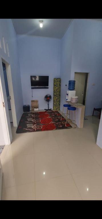 Halangan的住宿－Homestay Pandan，一间客厅,配有地毯和墙上的电视