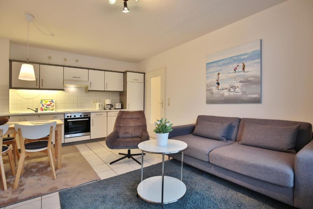 ein Wohnzimmer mit einem Sofa und einem Tisch in der Unterkunft Maison Baltique Niendorf Maison Baltique Appartement 15 in Häven