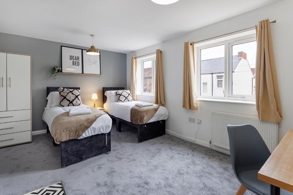 a bedroom with two beds and two windows at City Centre Studio 6 with Kitchenette, Free Wifi and Smart TV by Yoko Property in Middlesbrough