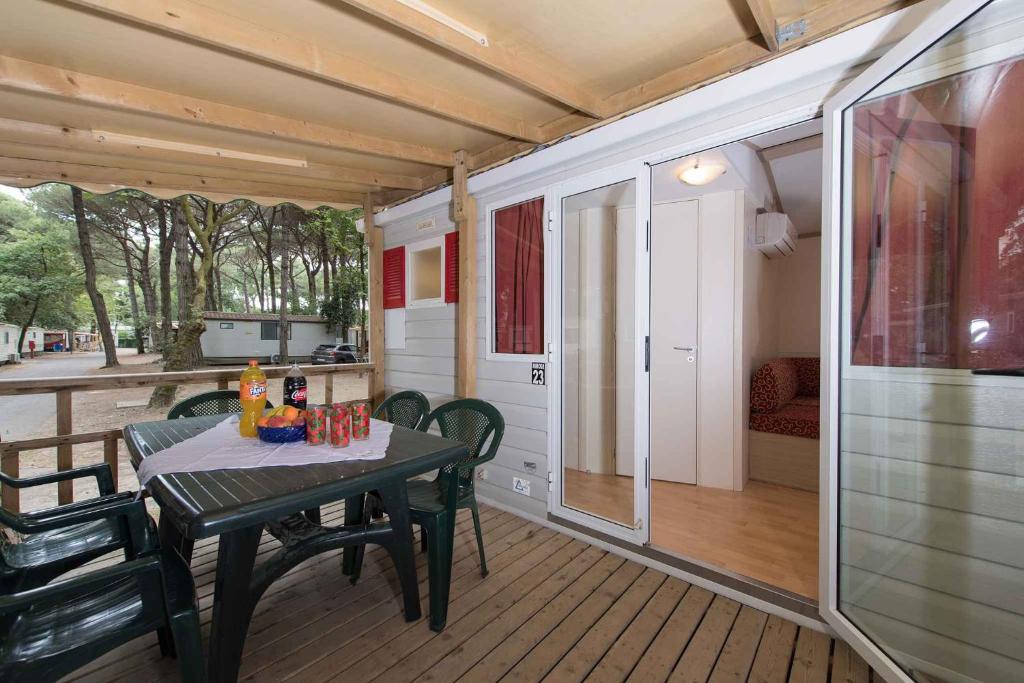 a porch with a table and chairs on a deck at Mobilehomes in Lido di Spina 21308 in Lido di Spina