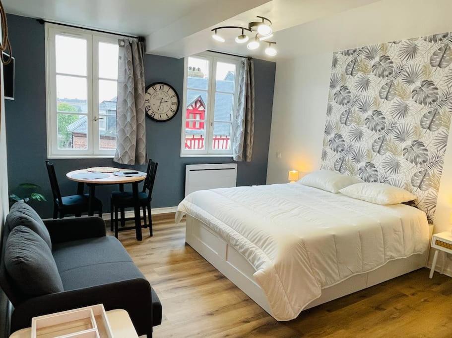 une chambre avec un lit, une table et un canapé dans l'établissement Studio Chez Sissi - hypercentre -, à Honfleur