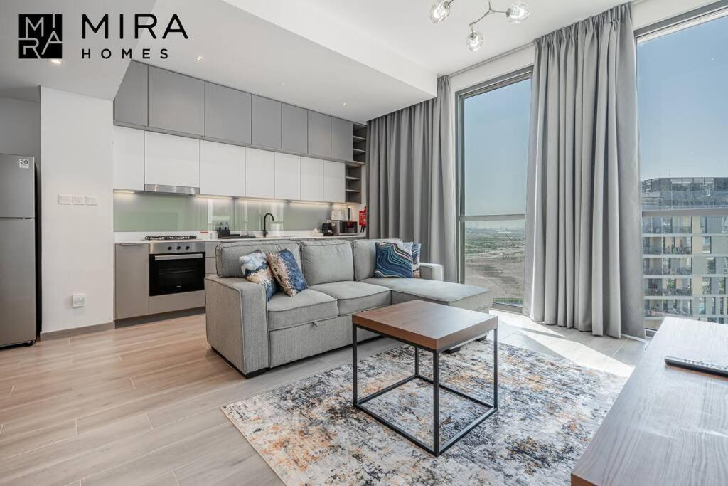 a living room with a couch and a kitchen at Mira Holiday Homes - Lovely 1 bedroom in Midtown in Dubai