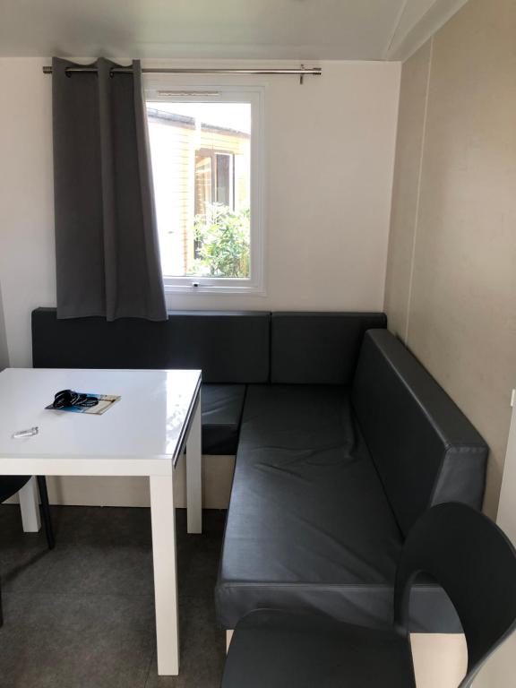 ein Wohnzimmer mit einem Sofa und einem Tisch in der Unterkunft Mobilhome 4 etoiles in Narbonne