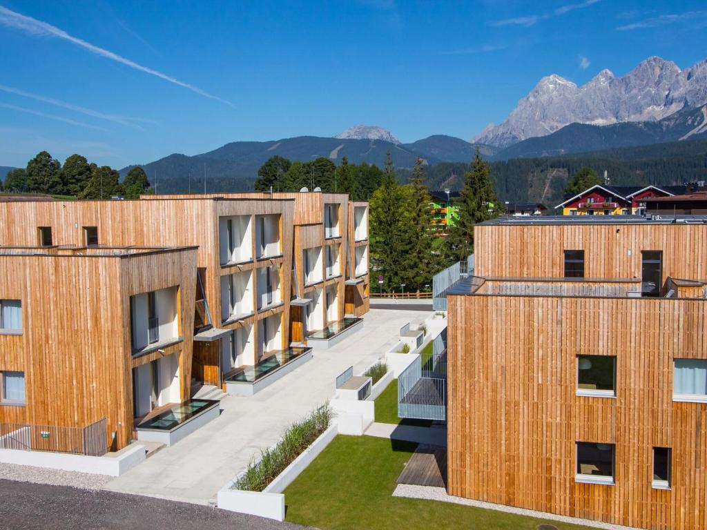 una fila de edificios con montañas en el fondo en Modern Apartment near Ski Area in Schladming, en Rohrmoos-Untertal