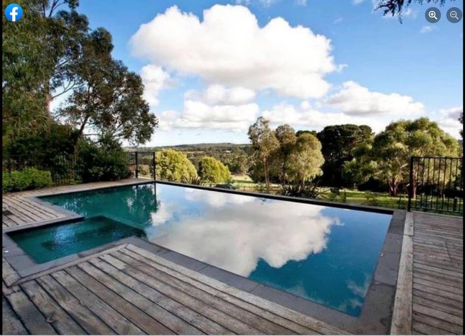 a large swimming pool with a reflection in the water at Patsy's Gate - Red Hill South in Red Hill South