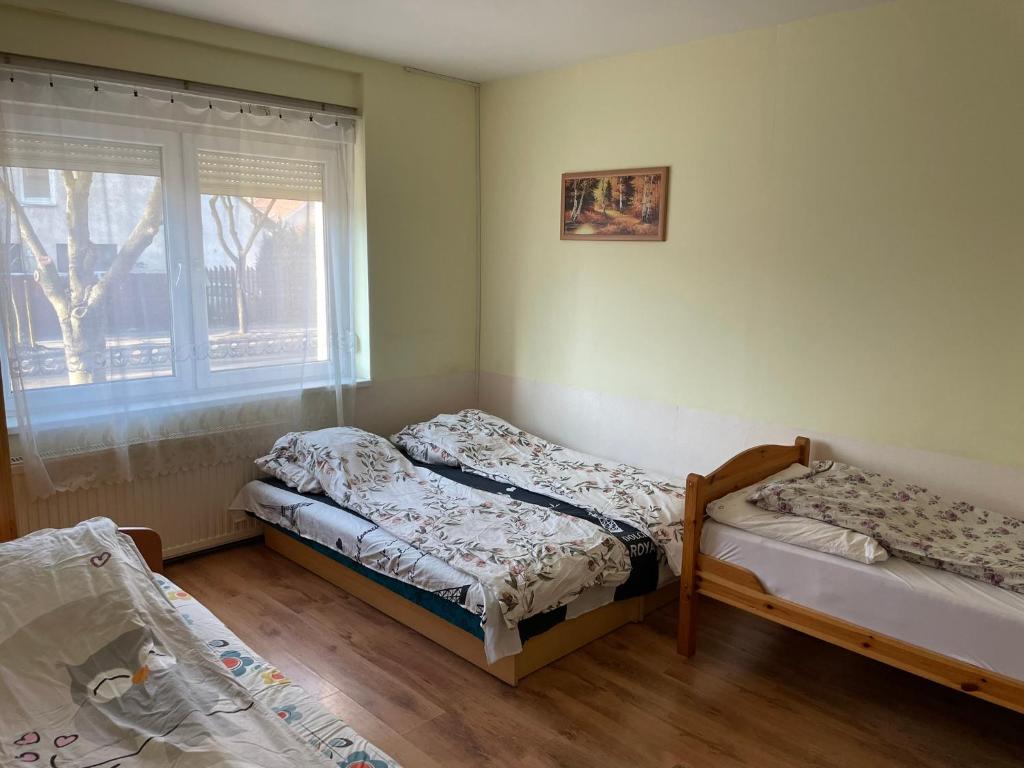 two beds in a room with a window at Red Locomotive Apartment in Budapest