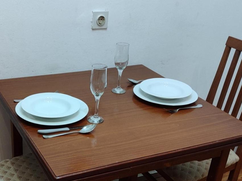 una mesa de madera con platos y copas de vino. en Red cross 58 apartment, en Vračar (historical)