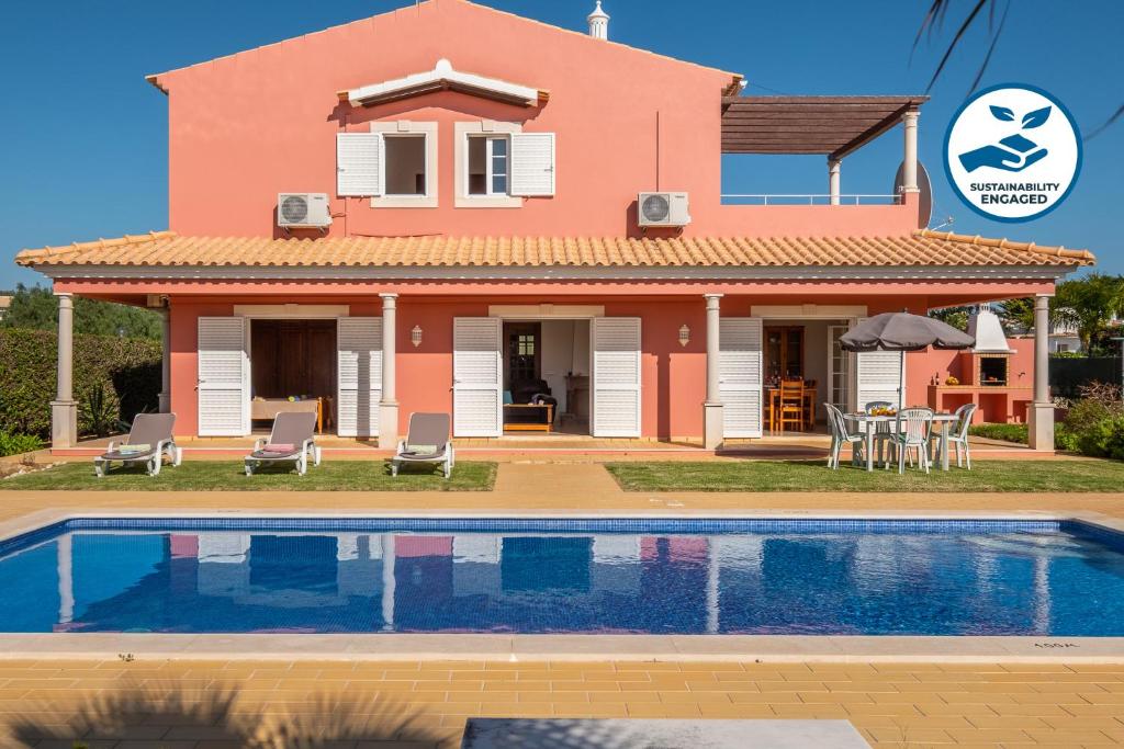 une maison avec une piscine en face de celle-ci dans l'établissement Villa Sunrise by Algarve Vacation, à Carvoeiro