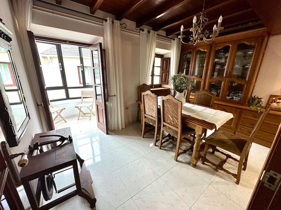 a dining room with a wooden table and chairs at A do Caseiro in O Barqueiro