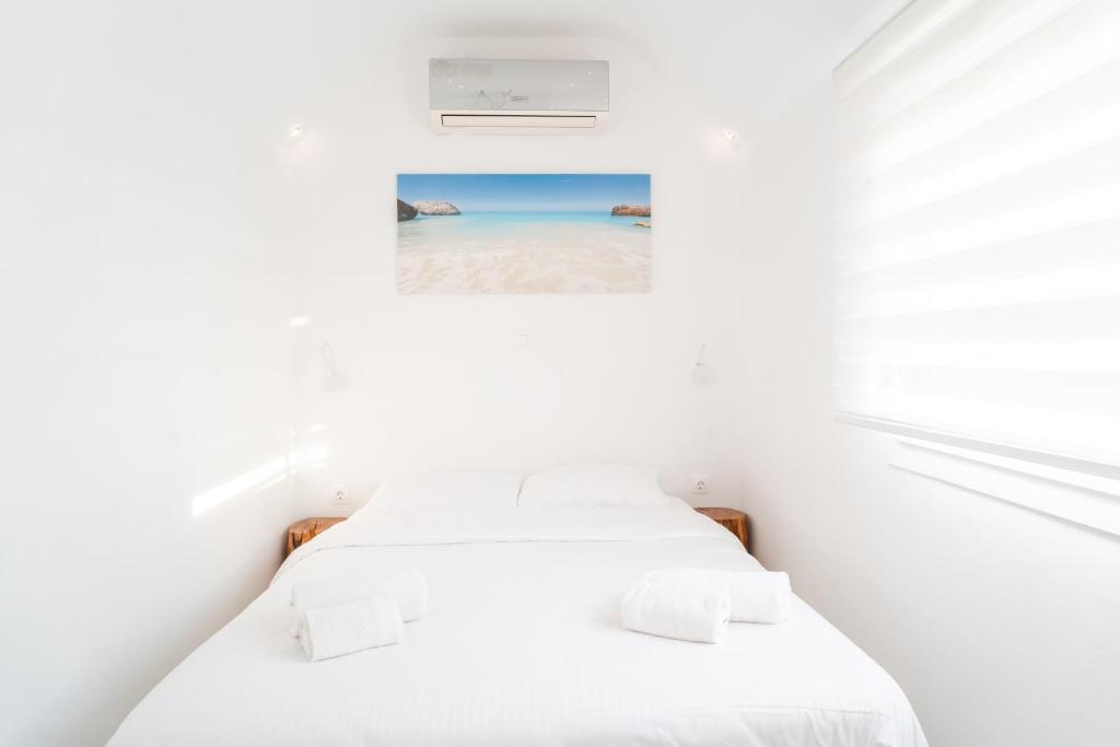 Ένα ή περισσότερα κρεβάτια σε δωμάτιο στο White House by Blue Waters Mykonos
