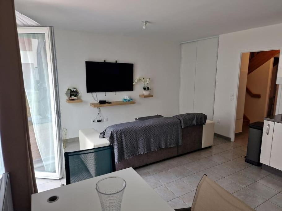 ein Wohnzimmer mit einem Flachbild-TV an der Wand in der Unterkunft Duplex avec terrasse et jardin in Dammarie-les-Lys
