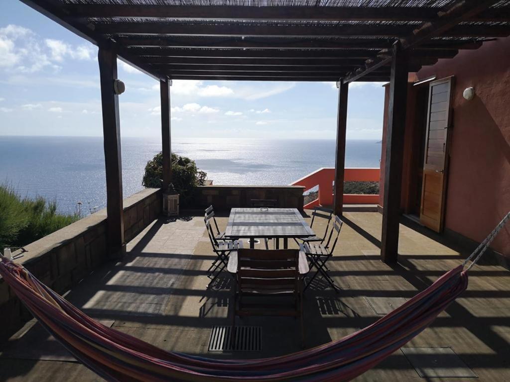 uma rede de descanso num alpendre com uma mesa e cadeiras em Villa su Capo Bianco em Ponza