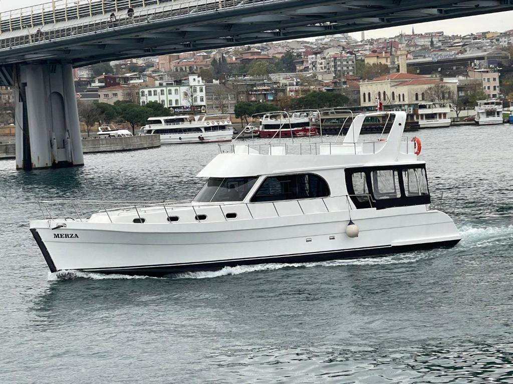 a white boat in the water under a bridge at Merza yatcılık in Istanbul