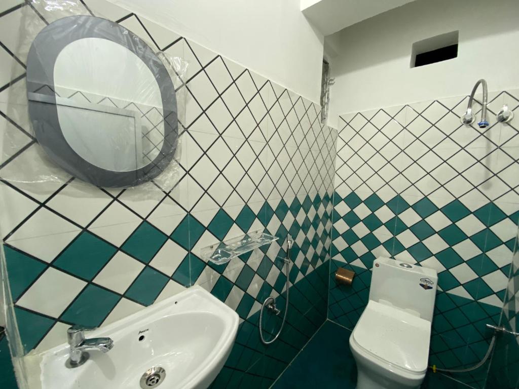 y baño con lavabo, espejo y aseo. en Shrubbery Homestay and Guest house, en Darjeeling