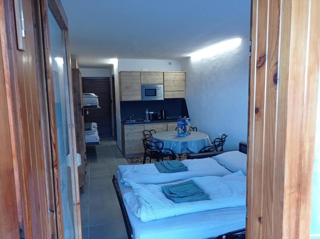 une chambre avec un lit et une cuisine avec une table dans l'établissement Petite Maison Larice, à Pila