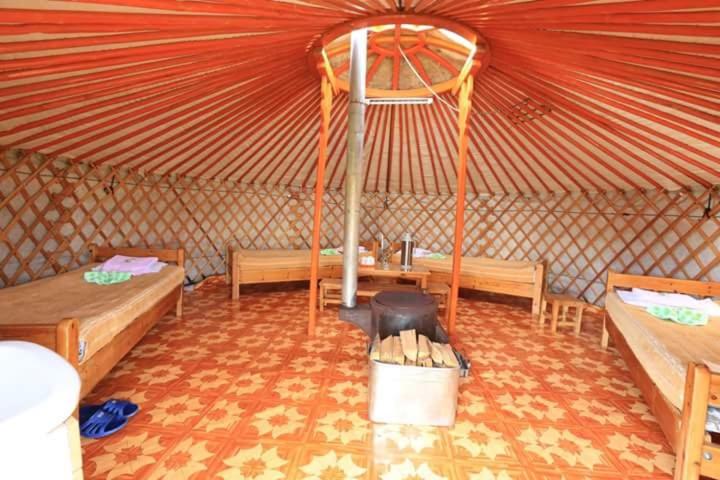 uma tenda com duas camas e um fogão em maidar-san tourist camp 