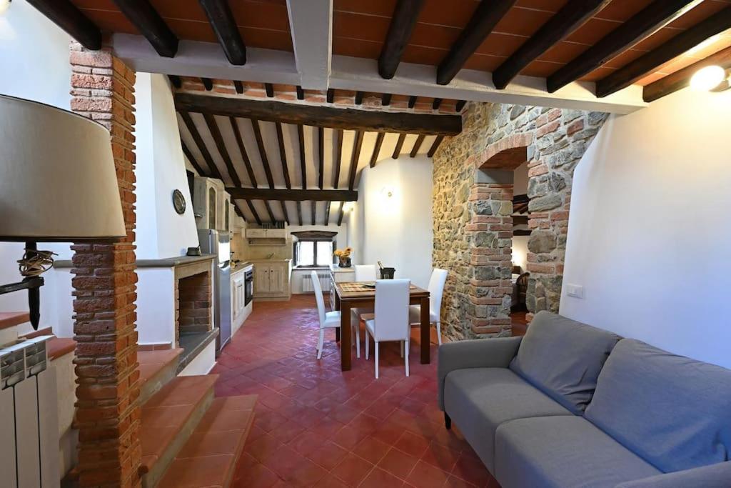 een woonkamer met een bank en een tafel met stoelen bij La casa nel borgo in Cavriglia