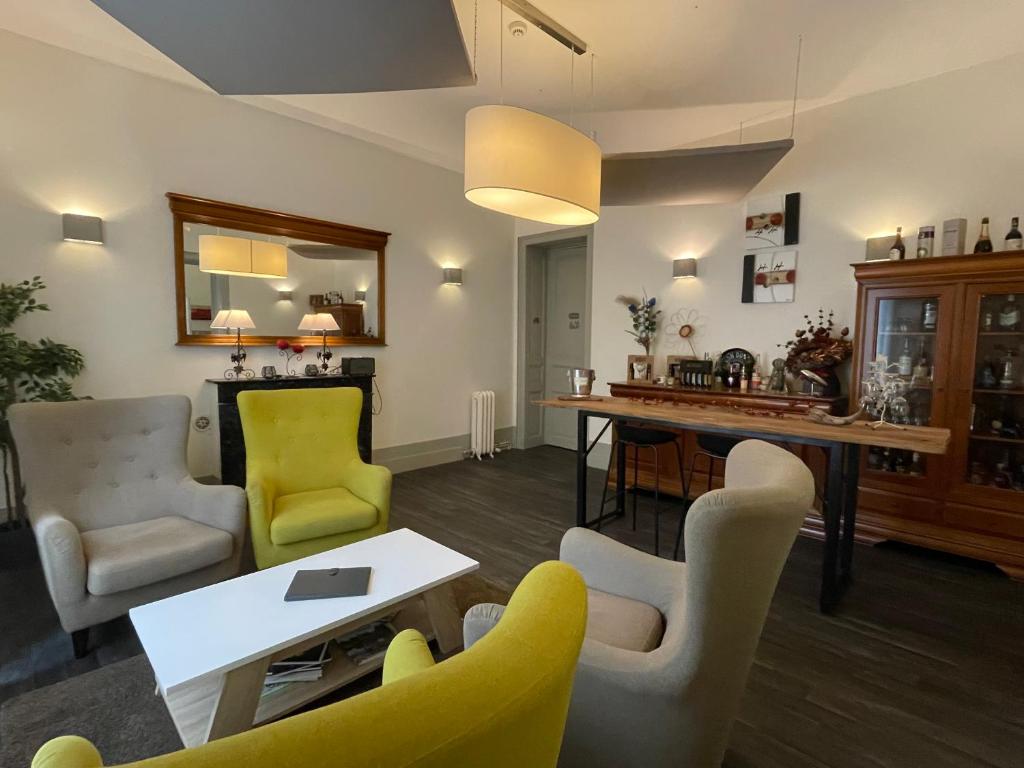 een woonkamer met een tafel en stoelen bij Le St Vincent in Roquefort