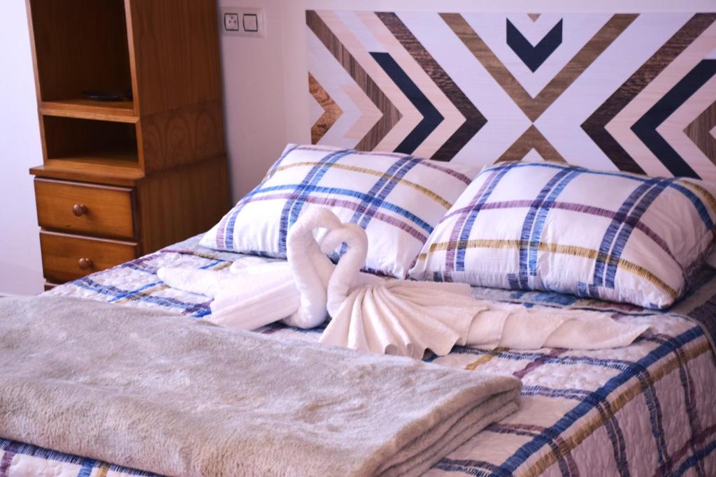un dormitorio con una cama con un animal de peluche en CAMBARAL 1D, en Luarca