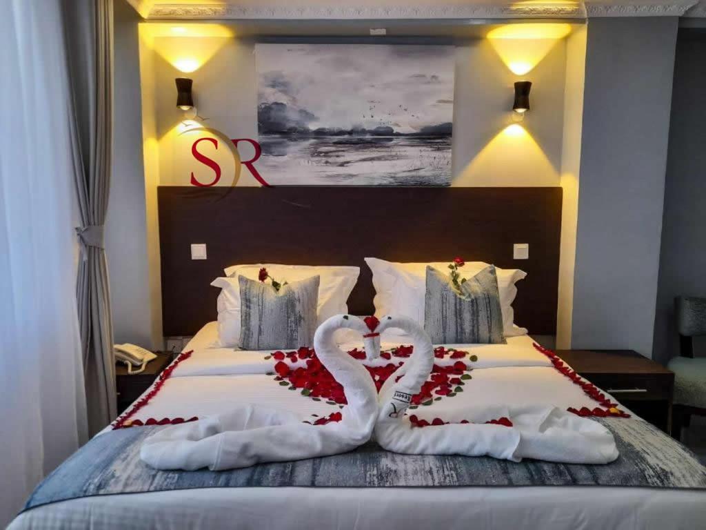 uma cama com dois cisnes feitos de rosas em Selella Resort em Kisumu