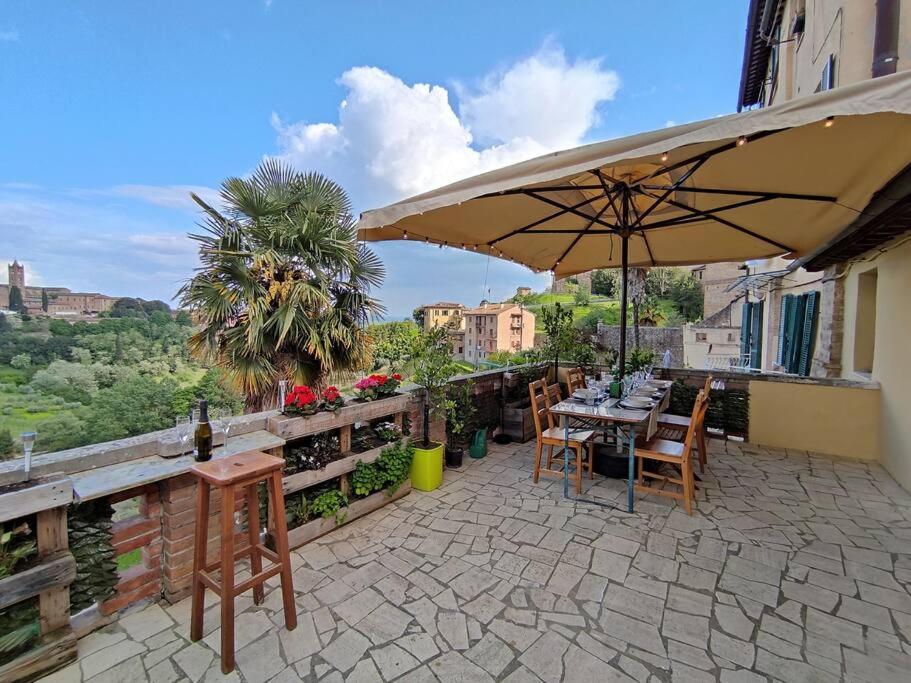a patio with an umbrella and a table and chairs at Gest Short Rent Siena 2 in Siena