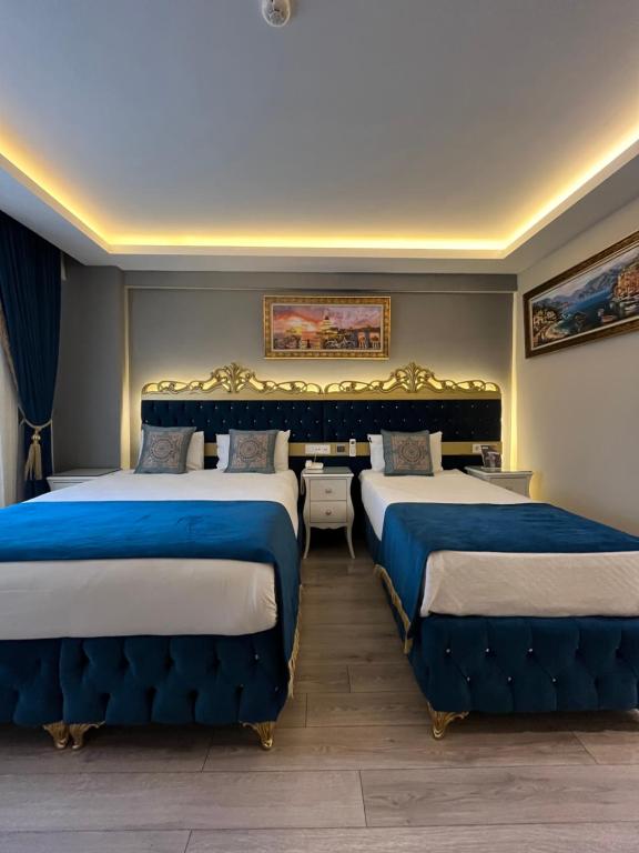 2 letti in una camera con blu e bianco di Constantinopolis Hotel a Istanbul