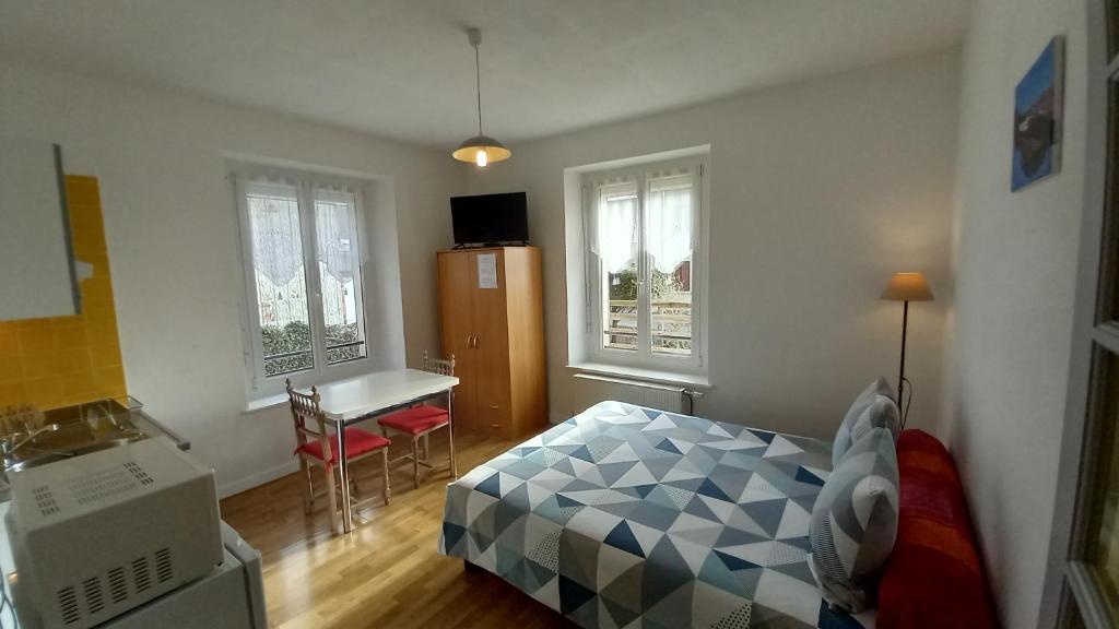 1 dormitorio con 1 cama, escritorio y 2 ventanas en Studio d'hôtes à 10 km de Gérardmer (Le Tholy), en Le Tholy