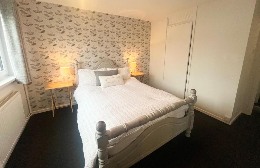 a bedroom with a white bed with two lamps on it at Spacious 2 double bed city home in Hereford