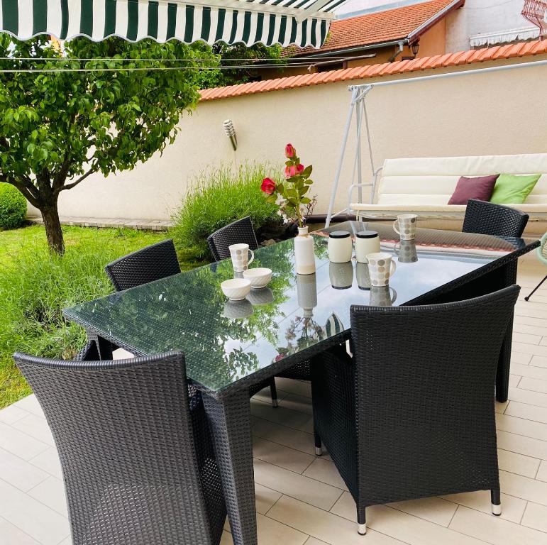 een tafel en stoelen op een patio bij Apartman Sweet Garden K&A in Zagreb