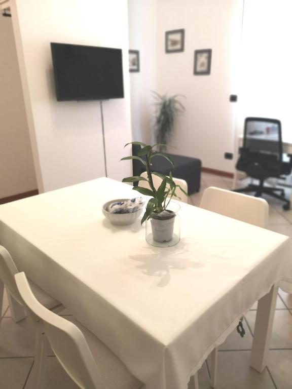 un tavolo bianco con una pianta sopra di Holiday Apartment - Brescia centro - PARCHEGGIO PRIVATO a Brescia