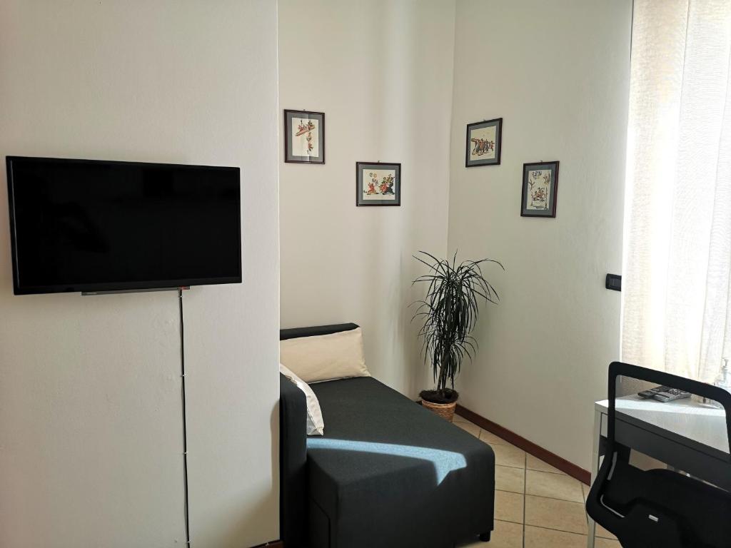 un soggiorno con una TV a schermo piatto su una parete di Holiday Apartment - Brescia centro - PARCHEGGIO PRIVATO a Brescia