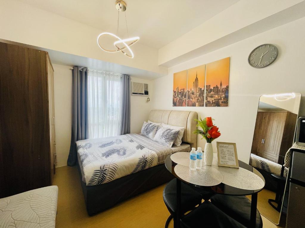 a small bedroom with a bed and a table at City View Studio Unit at Centrio Tower beside Ayala Mall in Cagayan de Oro