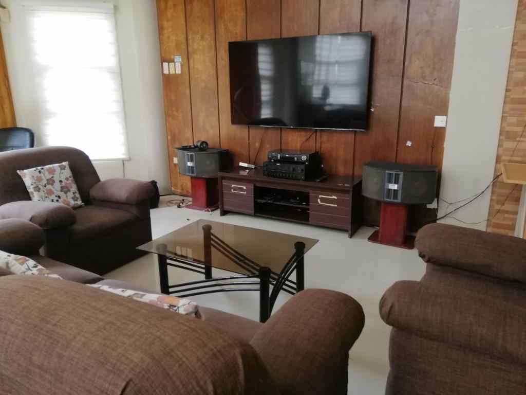 Il comprend un salon avec des canapés et une télévision à écran plat. dans l'établissement JD Homestays CDO, à Cagayán de Oro
