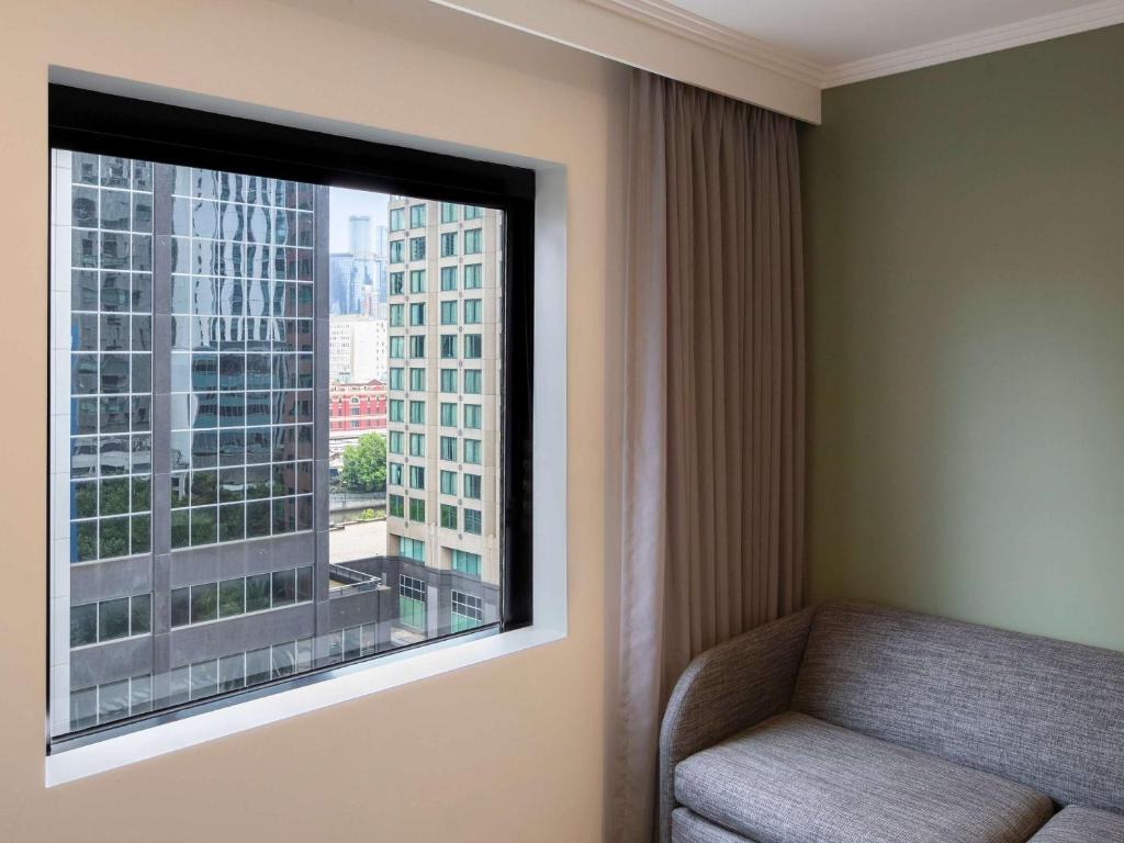 a window in a hotel room with a chair and a view at Mercure Melbourne Southbank in Melbourne