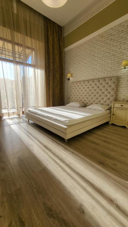 - une chambre avec un grand lit et une grande fenêtre dans l'établissement Hotel Menshikov, à Odessa