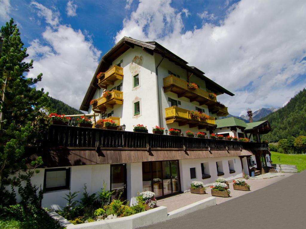 a building with flowers on the balconies of it at Hotel-Pension Edelweiss in Mallnitz