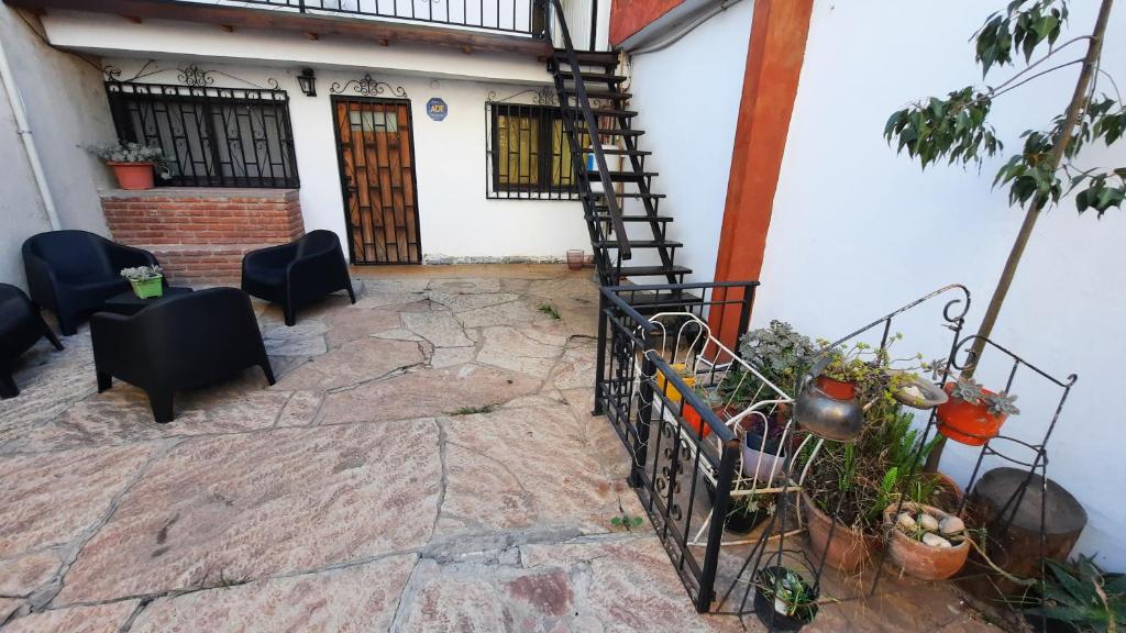 un patio con una escalera de caracol frente a una casa en Meraki Classic en Villa Carlos Paz