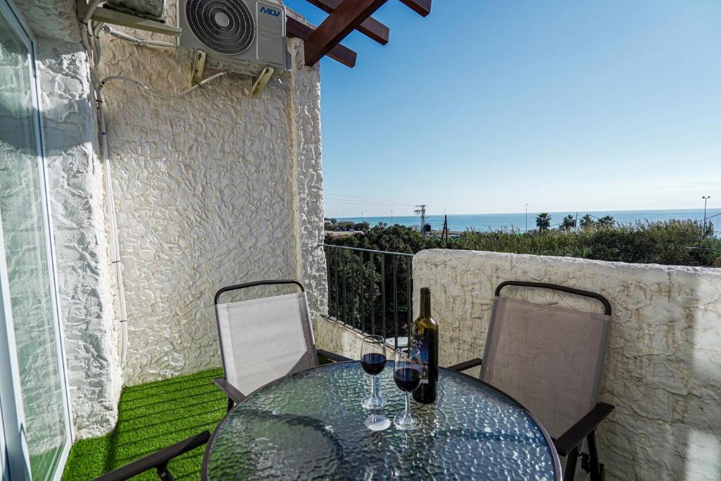 een glazen tafel en stoelen op een balkon met uitzicht op de oceaan bij Sunstay PRIMERA LINEA DE PLAYA! Aptos Rio Marina in Nerja